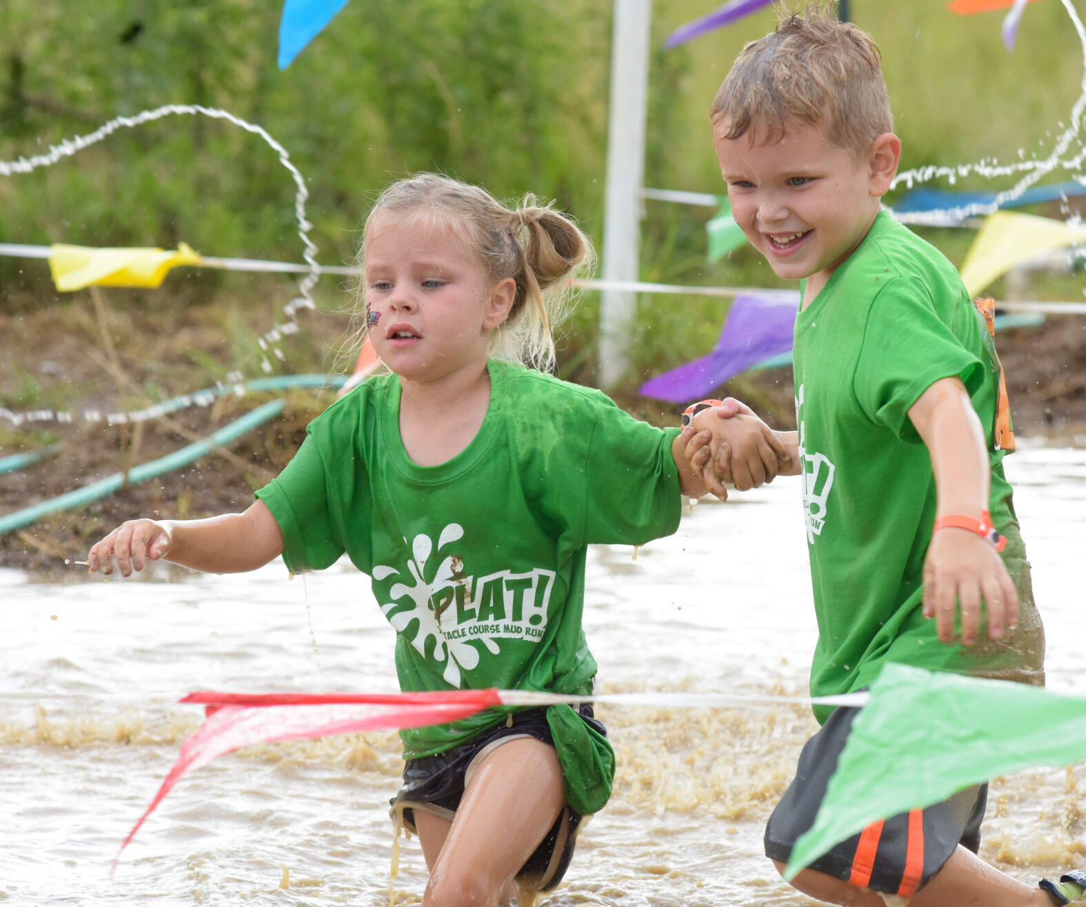 Quinn and Patton Nichols run through a mud puddle